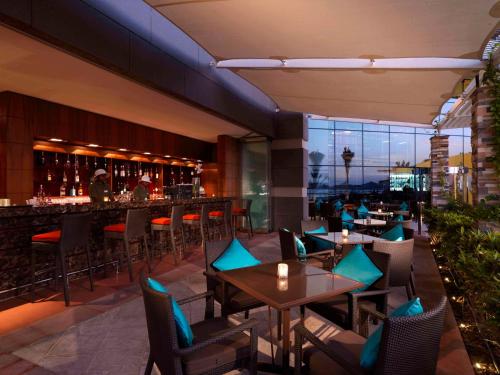 a restaurant with tables and chairs and a bar at Radisson Blu Hotel, Abu Dhabi Yas Island in Abu Dhabi