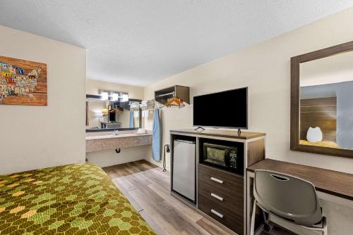 a hotel room with a bed and a flat screen tv at Econo Lodge Kingsport East in Kingsport