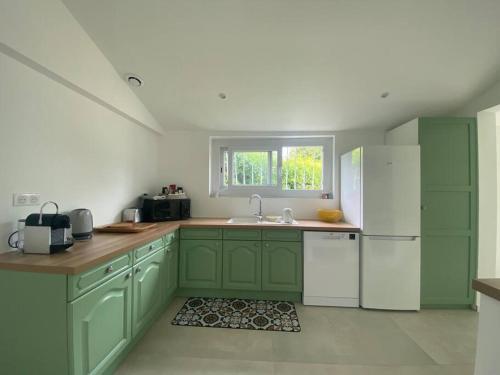 une cuisine avec des armoires vertes et un réfrigérateur blanc dans l'établissement Maison rénovée au charme typique du Bassin d'Arcachon, à Arès