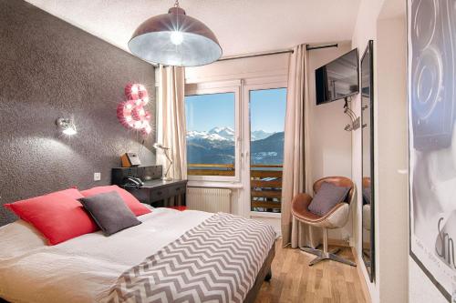 a bedroom with a bed with a view of a mountain at Hotel du Lac in Crans-Montana