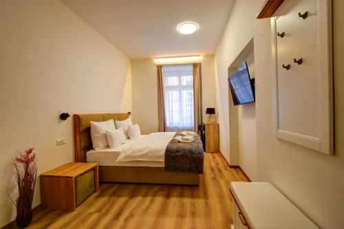 a small bedroom with a bed and a tv at Hotel Karlova Prague in Prague