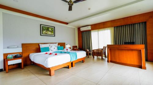 a hotel room with a bed and a desk and a room at Chandys Windy Woods Munnar in Munnar