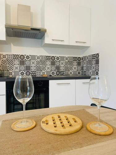 2 verres à vin et une planche de découpe sur un comptoir de cuisine dans l'établissement Jungle Love Room de l Hermitage, à Tournon-sur-Rhône