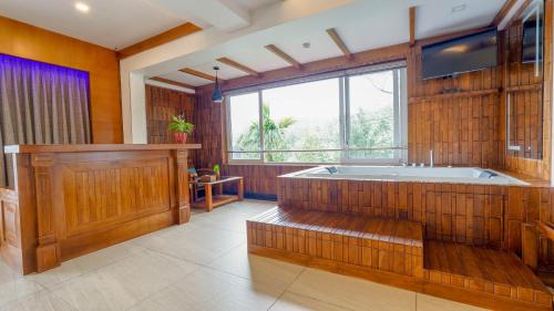 a large bathroom with a tub and a large window at Chandys Windy Woods Munnar in Munnar