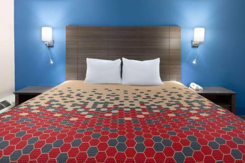 a large bed in a hotel room with two pillows at Baymont by Wyndham Bay City in Bay City