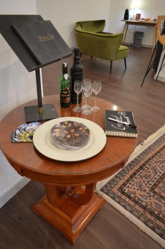 a table with a plate of food and wine glasses at CBA Suites Madeira in Funchal