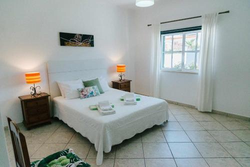 ein Schlafzimmer mit einem Bett mit zwei Lampen und einem Fenster in der Unterkunft Villa Jorge by Ecovillas Albufeira in Galé