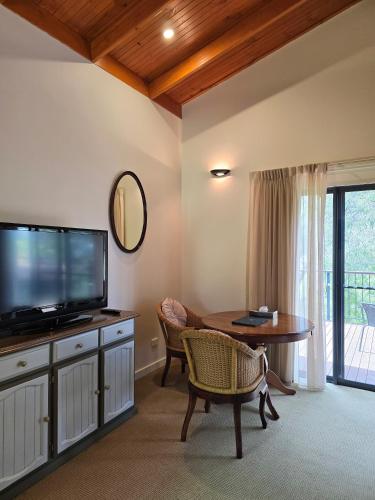 a living room with a television and a table at Karriview in Gracetown