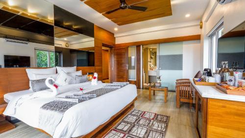 a bedroom with a large bed and a kitchen at Chandys Windy Woods Munnar in Munnar