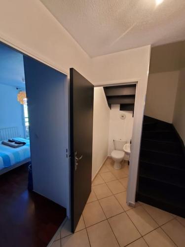 Cette chambre comprend une salle de bains avec des toilettes et une porte. dans l'établissement T4 terrasse et box - Groupama Stadium-Eurexpo-Lyon, à Meyzieu