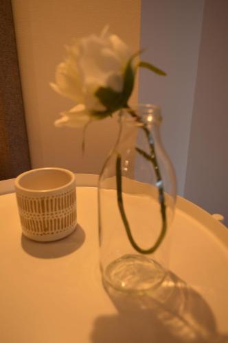 a white flower in a glass vase on a table at CBA Suites Madeira in Funchal