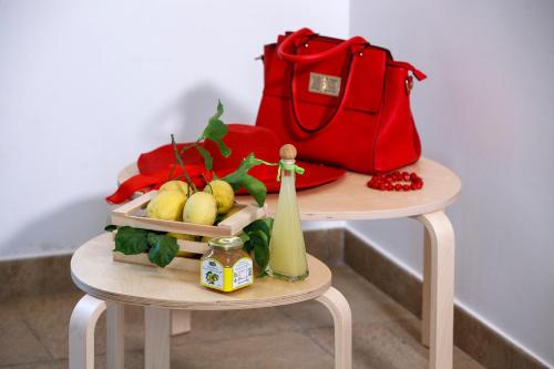 a table with a red purse and a table with fruit at VillaCrapolla Sorrento in Massa Lubrense