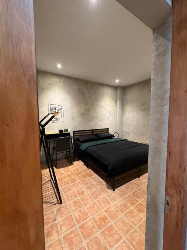 a bedroom with a black bed and a desk at Eisei House in Jakarta