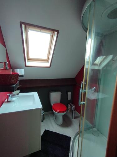 La salle de bains est pourvue de toilettes rouges et d'une fenêtre. dans l'établissement Simply fair by Disney, à Montry