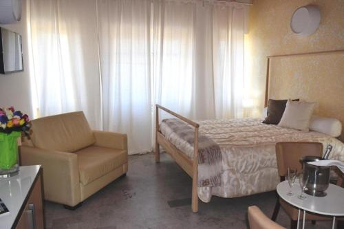a hotel room with a bed and a chair at Hotel Quadrifoglio in Pontecagnano