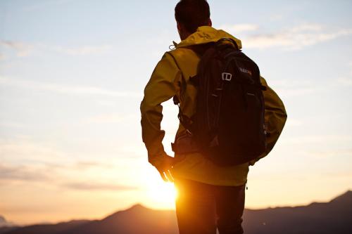 a man with a backpack looking at the sunset at Ferienwohnung Sonnblick in Ramsau im Zillertal