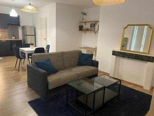 un salon avec un canapé et une table dans l'établissement Appartement cosy au cœur de Metz, à Metz