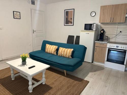 a living room with a blue couch and a table at Le nid douillet in Marmande
