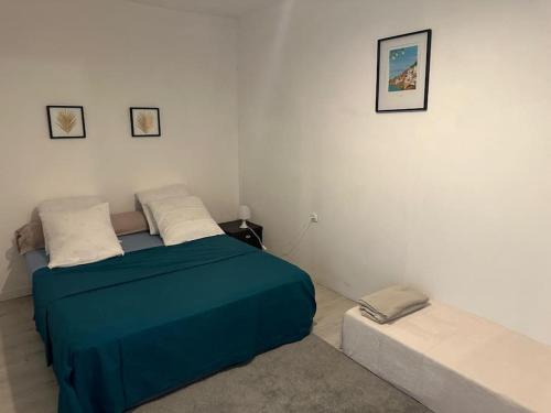 a bedroom with a blue bed and a couch at Le nid douillet in Marmande