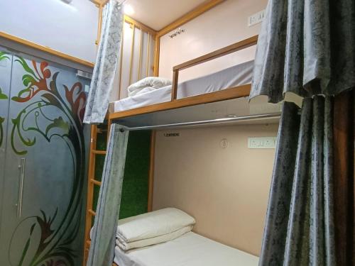 a room with two bunk beds and a curtain at Shree Madhvam AC Dormitory in Varanasi