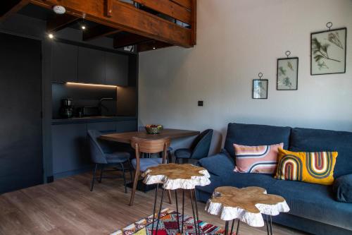 a living room with a blue couch and a table at ISKÖ CHALETS-HÖTEL, Col d'Aubisque in Gourette