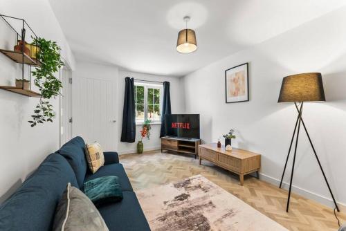 a living room with a blue couch and a tv at Large and Stylish Abode in Nottingham - Sleeps 15 in Nottingham