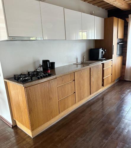 a kitchen with wooden cabinets and a stove top oven at Kiisa Jahi- ja Matkamaja in Holvandi