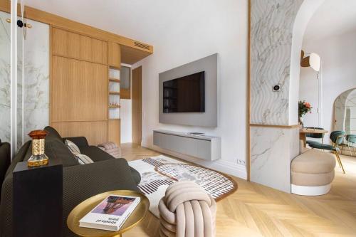 un salon avec un canapé et une télévision dans l'établissement Luxueuse Suite # 2 Chambres # Wagram # Paris 17, à Paris
