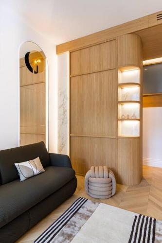 - un salon avec un canapé noir et une chaise dans l'établissement Luxueuse Suite # 2 Chambres # Wagram # Paris 17, à Paris