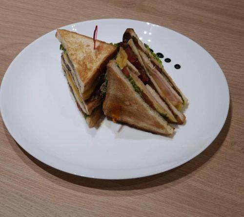 a sandwich cut in half on a white plate at Sport Hotel 2 in Cherkasy