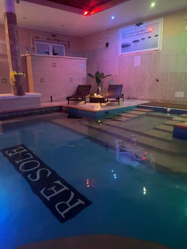 a swimming pool with two chairs and a table at Re Sole Resort&Spa in Grottaglie