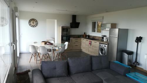 un salon avec un canapé et une table et une cuisine dans l'établissement Le grand large, à Bretteville