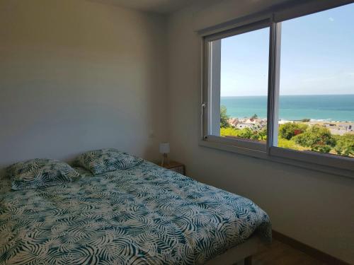 une chambre avec un lit avec vue sur l'océan dans l'établissement Le grand large, à Bretteville