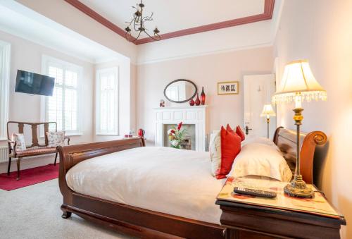 a bedroom with a bed and a table with a lamp at Mere Brook House in Wirral