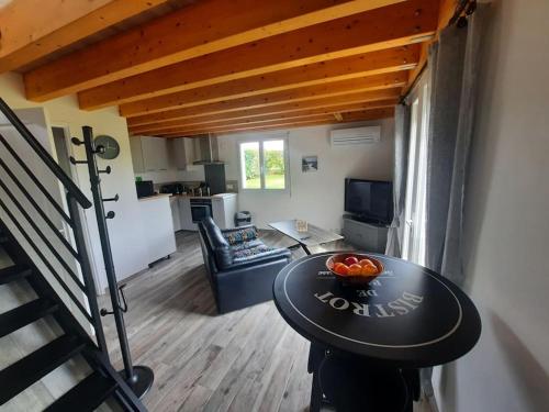 un salon avec une table avec un bol de fruits dessus dans l'établissement maison, à Faleyras