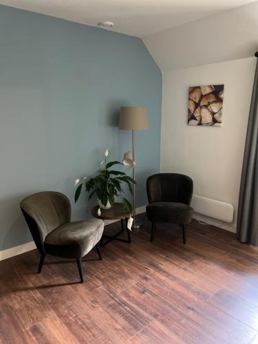 a waiting room with two chairs and a table at Hof van Balloo in Balloo