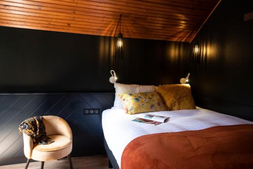 a bedroom with a bed and a chair at ISKÖ CHALETS-HÖTEL, Col d'Aubisque in Gourette