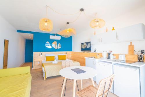 a kitchen and living room with a table and chairs at Hôtel Café Miramar in Le Grau-du-Roi