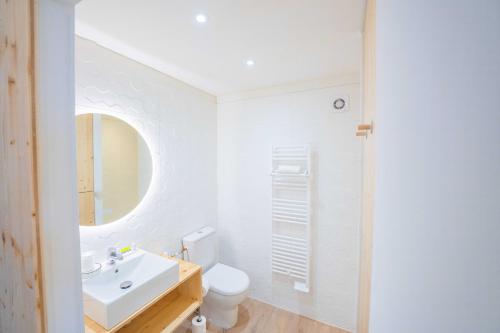 a white bathroom with a sink and a toilet at Hôtel Café Miramar in Le Grau-du-Roi