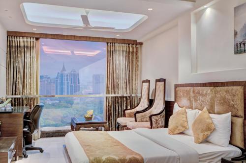 ニューデリーにあるEmpire Suites - Luxury Collection Hotelのベッドと机と窓のある寝室