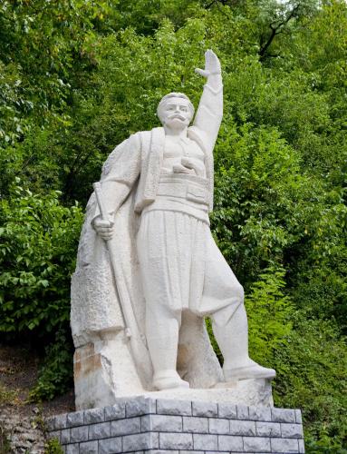 a statue of a man standing in front of trees at Family Hotel Teteven in Teteven