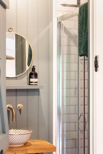 a bathroom with a sink and a mirror at Bijoux Shepherds Hut Lyme Regis in Lyme Regis