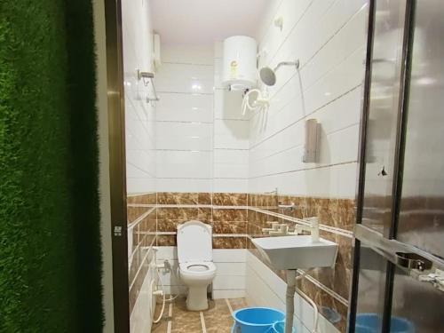a bathroom with a toilet and a sink at Shree Madhvam AC Dormitory in Varanasi