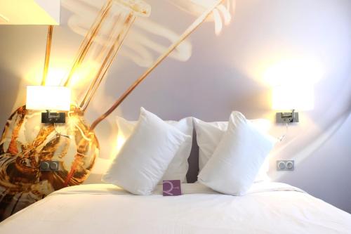 - un lit avec des oreillers blancs et 2 lampes dans l'établissement Mercure Paris Malakoff Parc des Expositions, à Malakoff
