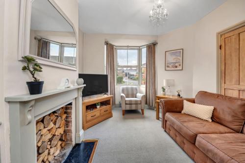 a living room with a couch and a fireplace at Delightful 10 St Martins - 2 bed, 2 bathroom with parking available in Bury Saint Edmunds