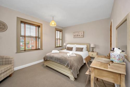 una camera da letto con un letto e una scrivania di Delightful 10 St Martins - 2 bed, 2 bathroom with parking available a Bury Saint Edmunds