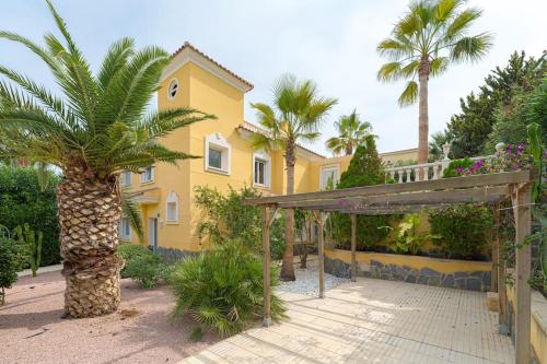 a yellow house with a palm tree in front of it at Cala Dor Villa 4 Bed 3 Bath Private Pool in El Campello