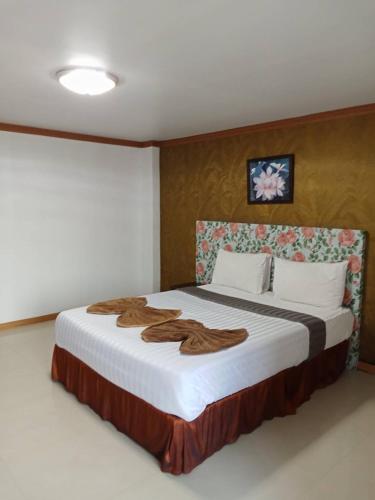 a bedroom with a large bed with a blanket on it at PS Hotel Saraburi in Sara Buri