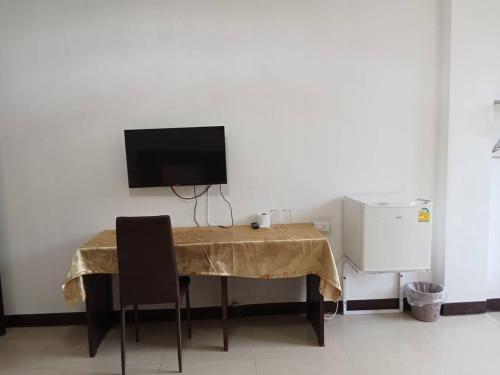 a table with two chairs and a television on a wall at PS Hotel Saraburi in Sara Buri