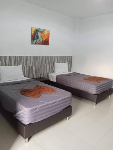 two beds sitting next to each other in a room at PS Hotel Saraburi in Sara Buri